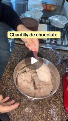 a person scooping ice cream into a bowl on top of a counter next to an oven