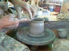 two hands are working on a pottery wheel