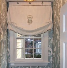 a bathroom with blue walls and white trim on the window sill, along with an ornate wallpaper