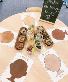 a table topped with lots of cut out shapes on top of cards and paper plates