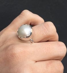 Choose your color and your ring size! This elegant and stately pearl ring is made from a beautiful and unique white cream 14mm Mabe South Sea AAA Pearl that has many hues including pink. The pearl has been set in sterling silver with a sterling silver ring band handmade from half dome wire. This ring has some height, the setting is almost 1/2 inch high. The white cream pearl is more matte than the other mabe pearls listed, but still has a luminescent quality that makes it captivating! Made to or White Pearl Drop Ring For Anniversary, Elegant White Moonstone Round Ring, Elegant Dome Ring With Cabochon For Wedding, Elegant White Round Moonstone Ring, Elegant White Moonstone Ring, Classic White Dome Ring For Wedding, White Oval Pearl Ring, Elegant Round Cabochon Pearl Ring, White Oval Dome Ring For Wedding