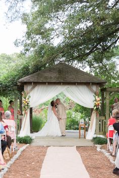 a bride and groom standing under a gazebo at the end of their wedding ceremony