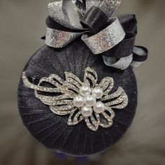 a close up of a hat with a bow and pearls