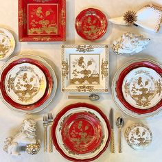 a table set with red and gold plates