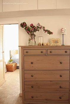 a wooden dresser with flowers on top of it