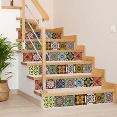 the stairs are decorated with colorful tiles and wood handrails, along with a potted plant