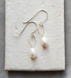 These white oval pearl earrings are a shimmering and chic pair. Delicately handcrafted, these freshwater pearls have been wrapped and end with tiny ball accents. The twisted links add another dainty touch and make them just the right length for many occasions.



These pearl earrings will transition with ease; perfect for causal chic to special evening. Causal Chic, Keshi Pearl Earrings, Pearl Teardrop Earrings, Teardrop Earrings Gold, Grey Pearl Earrings, Silver Wire Earrings, Moonstone Drop Earrings, Silver Chandelier Earrings, Pearl Chain Necklace