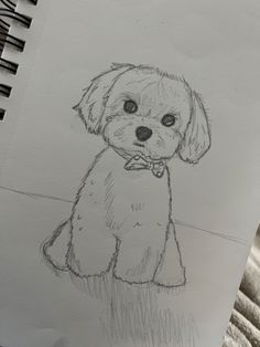 a drawing of a dog sitting on top of a table next to a pen and paper