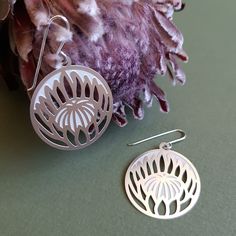 Inspired by the Australian Flower of the same name, our Protea Earrings feature both cut through and etched components within their design to bring the attention of admirers to the centre of the flower. These earrings are made from premium quality stainless steel and are finished with sterling silver earring hooks. The design of this piece alongside the material used allows for a pair of lightweight earrings which are very comfortable when wearing. These earrings measure 26mm x 29mm. Kira and Ev Protea Earrings, Protea Flower, Australian Flowers, Dangle Earrings Silver, Botanical Jewelry, Lightweight Earrings, Silver Drop Earrings, Light Weight Earrings, Silver Earrings Dangle