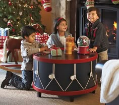 two children playing with toys in front of a christmas tree