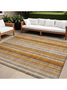 an outdoor area rug with wooden furniture and plants