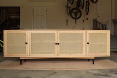 a large wooden cabinet sitting on top of a floor next to a wall mounted bike rack