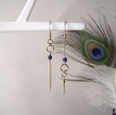 "These mismatched earrings are part of the \"Comète\" collection. They are created in gold-filled yellow gold and genuine Lapis Lazuli pearls. The fine dangling chains represent the tail of a comet hurtling along the edge of the universe... The combination of gold and the deep blue hue of Lapis Lazuli works beautifully.  They are asymmetrical to bring a touch of originality to the classic gold earrings.  This pair of earrings is also available in rose gold and white mother-of-pearl pearls, right here : https://www.etsy.com/fr/listing/1614520595/boucles-doreilles-asymetriques-et?click_key=b777fc9fb019e88954f0b046d089bada0a01e67b%3A1614520595&click_sum=50aeb6e5&ref=shop_home_active_1&frs=1 What is gold filled? It is a metal combining a brass base covered with a thick layer of gold, about 25 Pearl Bead Earrings, Elegant Blue Earrings With Ear Wire, Cute Earring Ideas, Mismatch Earrings, Making Earrings, Unique Diy Earrings Ideas, Asymetrical Earings, Blue Lapis Lazuli Jewelry With Ear Wire, Asymetrical Earrings