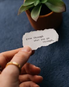 a person holding a piece of paper with the words grow through what you go through