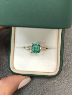 A classic Colombian emerald and diamond engagement, statement, or right-hand ring. Dexterously crafted in gleaming 14K gold this ring features a 1.81-carat natural Colombian emerald-emerald cut from the famous Chivor mines. Set in a secure prong setting, this extraordinary emerald has a bright green color and glow. This emerald has very good eye clarity with natural Jardins that occur in all earth-mined emeralds. Pear diamonds weighing 0.30pts total accent on either side of the emerald. Setting: Crazy Rich Asians Wedding Ring, Emerald Cut Rings Gold, Small Green Engagement Ring, Colombian Emerald Engagement Ring, Understated Engagement Rings, Crazy Rich Asians Ring, Wedding Manifestation, Wedding Rings Emerald, Three Stone Engagement Rings Emerald