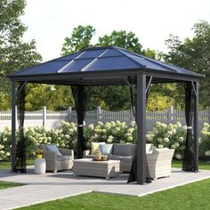 an outdoor gazebo with couches and tables in the grass