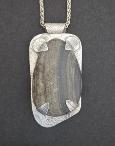 This piece began with a river rock from Big Creek, N.C. which was then hand-shaped and polished. The backplate,bail and tabs were hand-sculpted in fine silver metal clay and fired. The tabs and bail were torch fired to the backplate, which was polished, patina was added and it was polished again. Then the stone was hand-set. It measures 1 1/4" Wide by 2 5/8" Long by 1/2" Deep and comes on a 20" Sterling Silver Wheat Chain. Metal Clay Designs, Jewelry Metalsmithing, Metal Clay Art, Metal Clay Tutorial, Metal Jewelry Handmade, Kinetic Jewelry, Etched Jewelry, Pmc Jewelry, Texture Jewelry