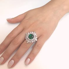 This brilliant sunburst style ring is crowned with a green emerald cut emerald 4.65 carat stone from Zambia. Accented by round and pear diamonds 5.18 carat total. Platinum 950. Diamonds are white and natural and in G-H Color Clarity VS. A gorgeous Art Deco vintage inspired ring that will get you attention. Length: 2.1 cm Width. 2.1 cm Weight: 16.12 g [shortcode] [video] [/video] [/shortcode] Luxury Emerald Ring With Vvs Clarity, Luxury Classic Emerald Ring With Vvs Clarity, 5 Carat Emerald Ring, Diamond Ring Indian, Cocktail Rings Gold, Luxury Vvs Clarity Diamond Emerald Ring, Diamond And Emerald Ring, Cocktail Rings Diamond, Modern Diamond Cocktail Rings