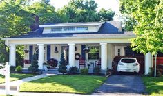 a white car is parked in front of a house with porches and wreaths