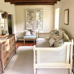 a living room filled with furniture next to a wooden dresser and window covered in white curtains