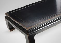 a black wooden table sitting on top of a white floor