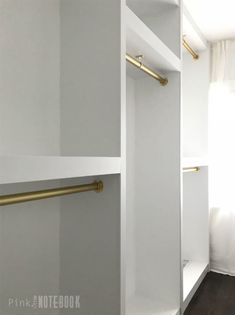 an empty white closet with gold handles