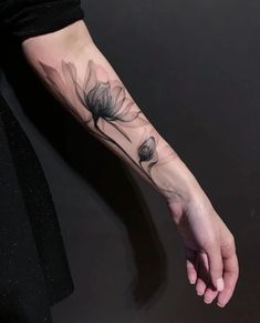 a woman's arm with a flower tattoo on the left side of her hand