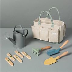 a garden tool set sitting on top of a table next to a bag and utensils