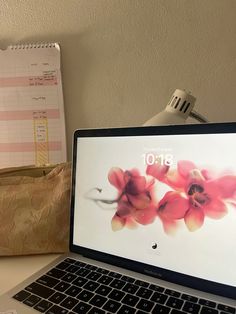 an open laptop computer sitting on top of a desk next to a cup and pen