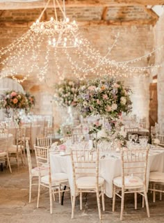 the tables are set up with white linens and floral centerpieces for an elegant wedding reception