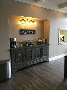 a coffee bar with lights above it on the wall