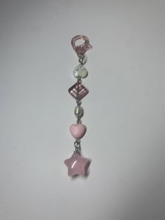 a pink and white beaded keychain with a star shaped charm on it