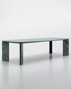 a green marble table with two legs on the top and one leg extended to the side