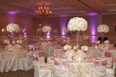 the tables are set with white and pink flowers