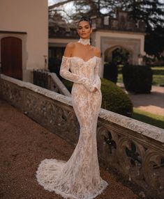 a woman in a wedding dress standing on a balcony