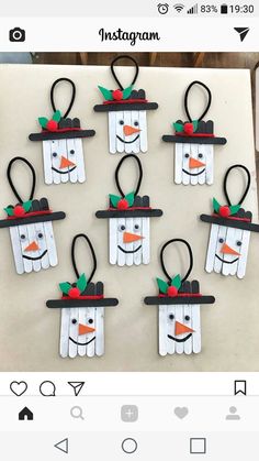 snowmen made out of popsicle sticks are hanging on the wall in front of an instagram