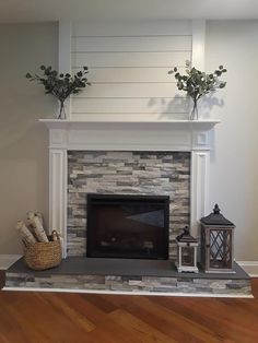 a living room with a fire place and vases on top of the mantel