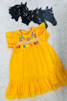 Dress features with floral embroidery on yellow background with pompoms tassels. Spandex & Polyester fabric Including: Dress only Festive Yellow Ruffled Dress, Festive Cotton Dress With Embroidered Hem, Traditional Yellow Cotton Dress, Yellow Bohemian Dress With Tassels, Yellow Cotton Dress With Floral Embroidery, Festive Yellow Embroidered Dress With Floral Details, Yellow Bohemian Dress With Floral Embroidery, Traditional Yellow Embroidered Cotton Dress, Festive Yellow Short Sleeve Dress