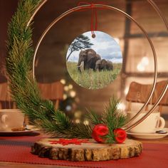 an ornament is hanging on a table next to a cup and saucer