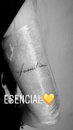 a woman's arm with the words essential written on it and a yellow heart