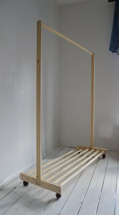 a bed frame sitting on top of a wooden floor next to a white wall in a room