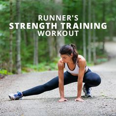 a woman is doing push ups in the middle of a road with trees behind her