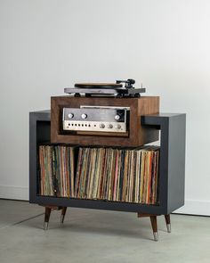 an old record player is sitting on top of a cabinet