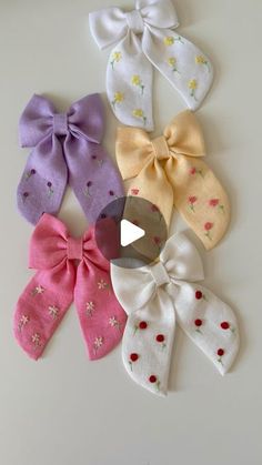 six different colored bows are arranged on a white surface