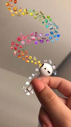 a hand holding a tiny toy with many different objects coming out of it's mouth