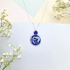 Elevate your style with our Blue Floral Circular Pendant Necklace. This unique necklace features a circular pendant meticulously handcrafted from polymer clay, showcasing a vibrant bright blue hue adorned with intricately hand-painted florals. The pendant's design includes exquisite raised detailing, including delicate leaves and tulips, adding depth and texture to this wearable work of art. Features: Design: The circular pendant boasts a captivating bright blue design with intricate hand-painted florals. Material: Crafted from polymer clay, this pendant is lightweight and durable for all-day comfort. Artisan-Made: This necklace is lovingly handmade by our small artisan team, ensuring the highest level of craftsmanship and care. Size: The circular pendant is eye-catching and adds a touch o Handmade Blue Medallion Necklace, Handmade Blue Polymer Clay Necklaces, Blue Hand Painted Round Pendant Necklace, Hand Painted Blue Round Pendant Necklace, Artisan Blue Hand Painted Necklaces, Artisan Hand Painted Blue Necklaces, Handmade Polymer Clay Round Pendant Necklace, Blue Artisan Polymer Clay Jewelry, Handmade Round Polymer Clay Pendant Necklace