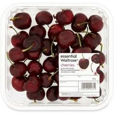 fresh cherries are in a plastic container on a white background with the label for essential waitrosee