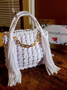 a white crocheted purse sitting on top of a wooden table