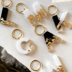 several pairs of gold and white rings sitting on top of a marble slabd surface