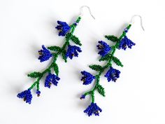 two pairs of blue and green beaded earrings with leaves on the end of them